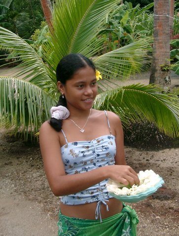 Traditional French Polynesian welcome by young native woman with flowers