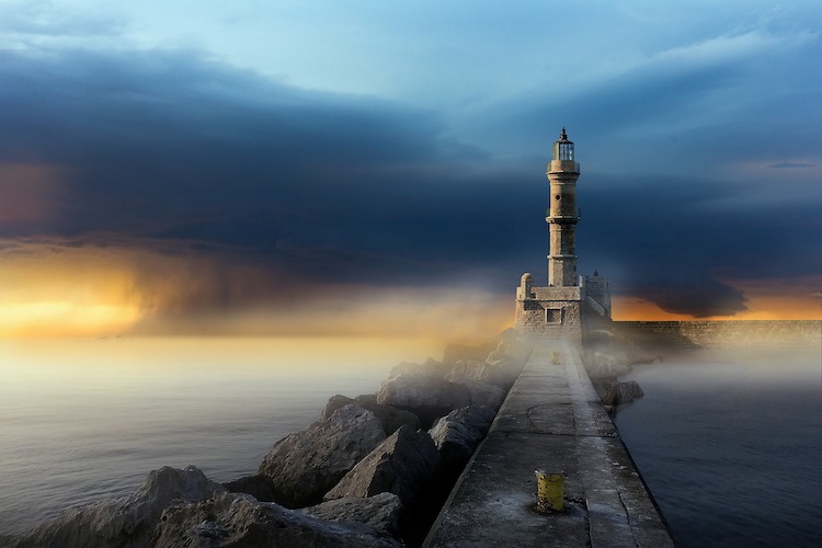 Tower and wall with storm coming up behind it from the sea