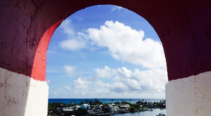 Red archway shows view of white clouds over the Caribbean Sea in Abaco Islands, Bahamas