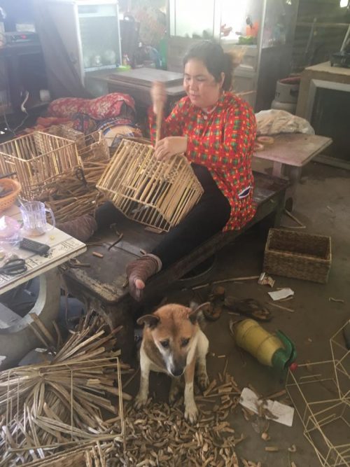 Basketweaver in workshop with her dog AQUA MEKONG