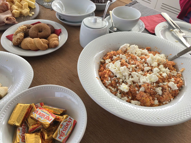 Traditional Greek breakfast of eggs, feta and olive oil with baked goods