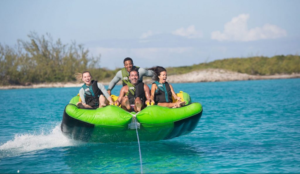 Raft full of laughing yacht charter couples pulled by motor yacht LADY JOY
