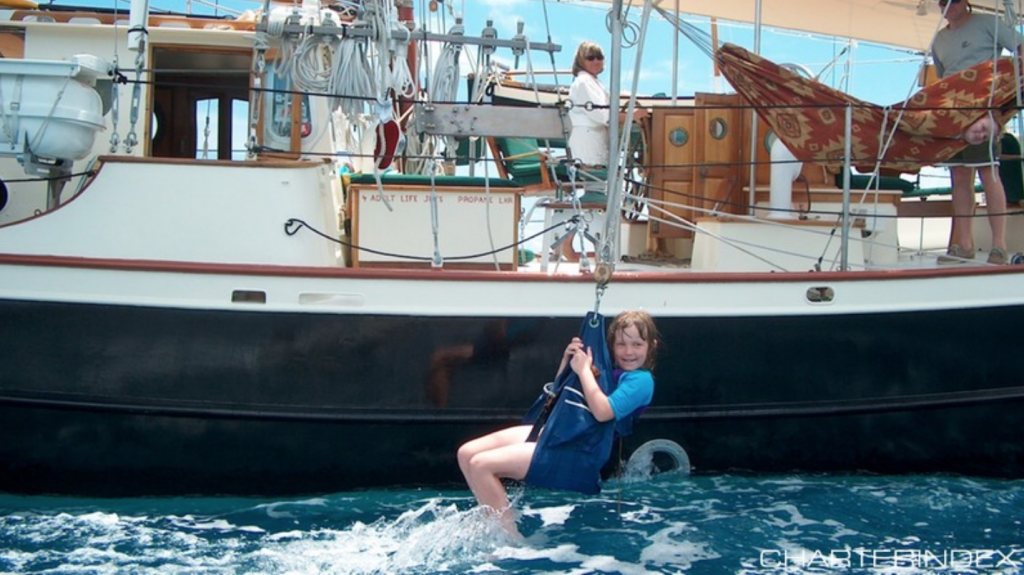 Girl on a Swing off the 72ft sailing yacht BONNIE LYNN, a modified version of designer Merrit Walter’s Trade Rover Schooner