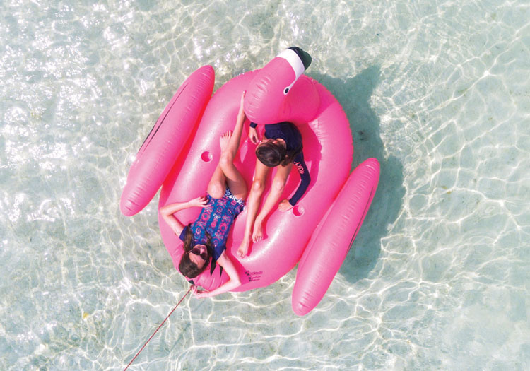 Happy passengers on the M/Y LADY J's towable pink flamingo