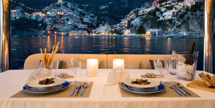 Dining Table for evening dinner on the 70ft Sunreef sailing yacht catamaran Ombre Blu 3 moored off Positano, Italy on the Amalfi Coast