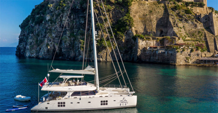 70ft Sunreef sailing catamaran OMBRE BLU³ off an Amalfi Coast Italy fort in the Western Mediterranean