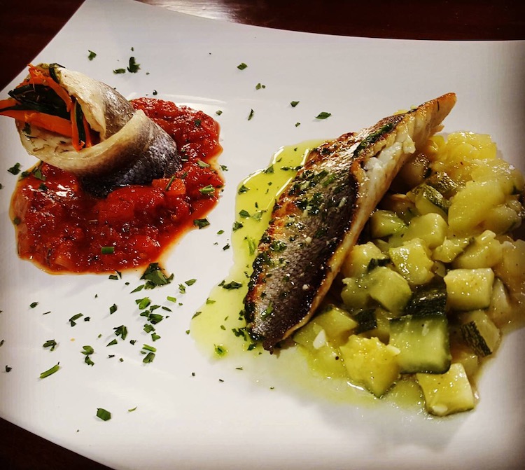 Two fish dishes: one in red sauce, the other on a bed of fresh pineapple