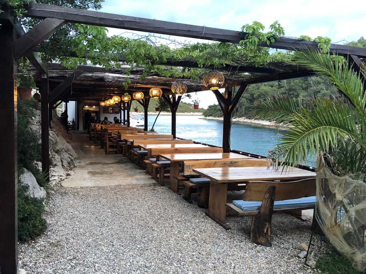 Restaurant with tables and trellis along the water in Croatia