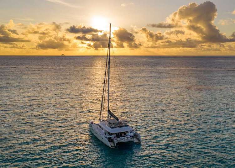 62ft Lagoon sailing catamaran S/Y HUNTRESS (formerly TWIN FLAME) on the water during golden sunset