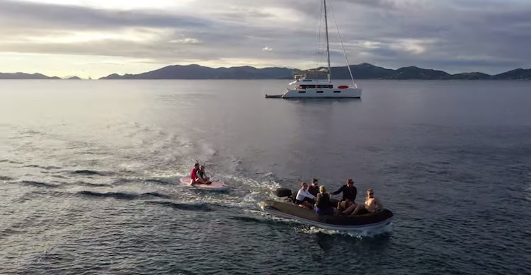 Dinghy towing a surfboard in the British Virgin Islands off 65ft sailing catamaran LOLALITA